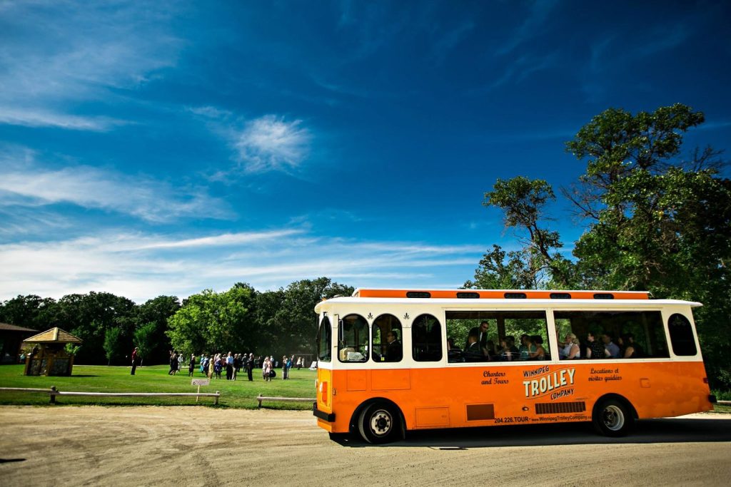 Orange trolley parked in a Winnipeg park on a wedding day